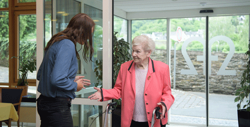 Eine Mitarbeiterin des Seniorenzentrums St. Hedwig Cochem begrüßt eine neue Bewohnerin